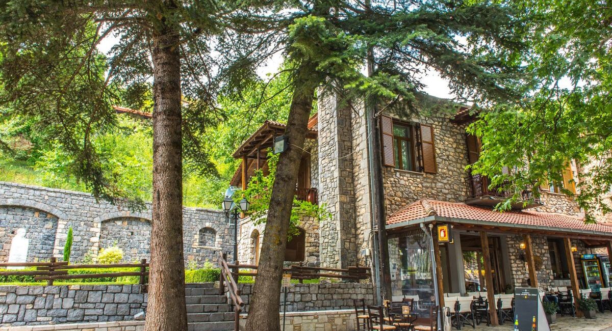 Village kafeneio on a stone square under fir trees in the mountains of Arcadia